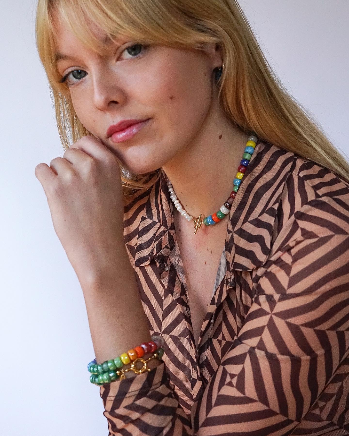 Asymmetric necklace made of recycled rainbow crystal crow beads and freshwater pearls with a gold-plated toggle clasp.