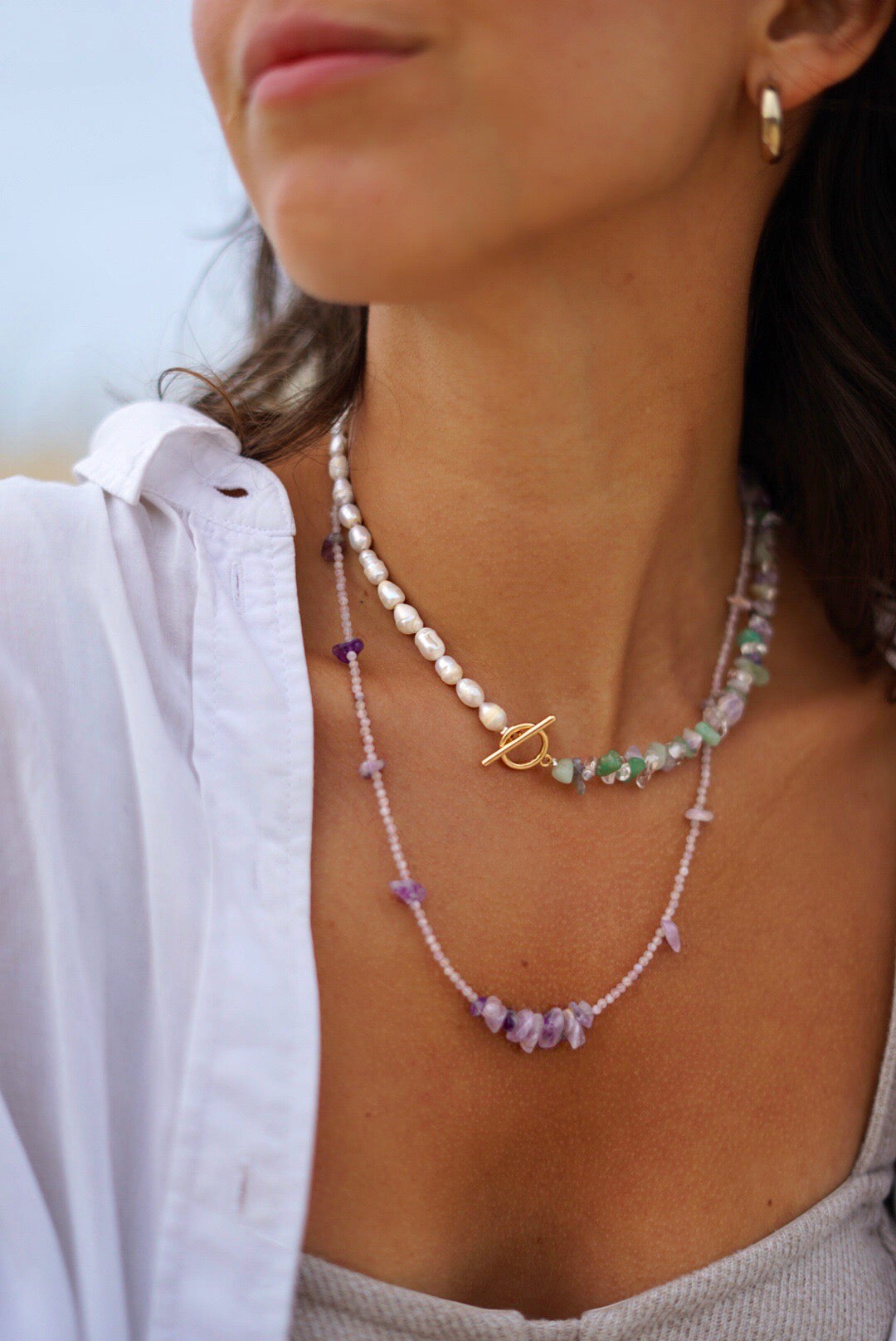 Asymmetric purple necklace with amethyst, green aventurine, crystal quartz and freshwater pearls with a gold-plated toggle clasp.