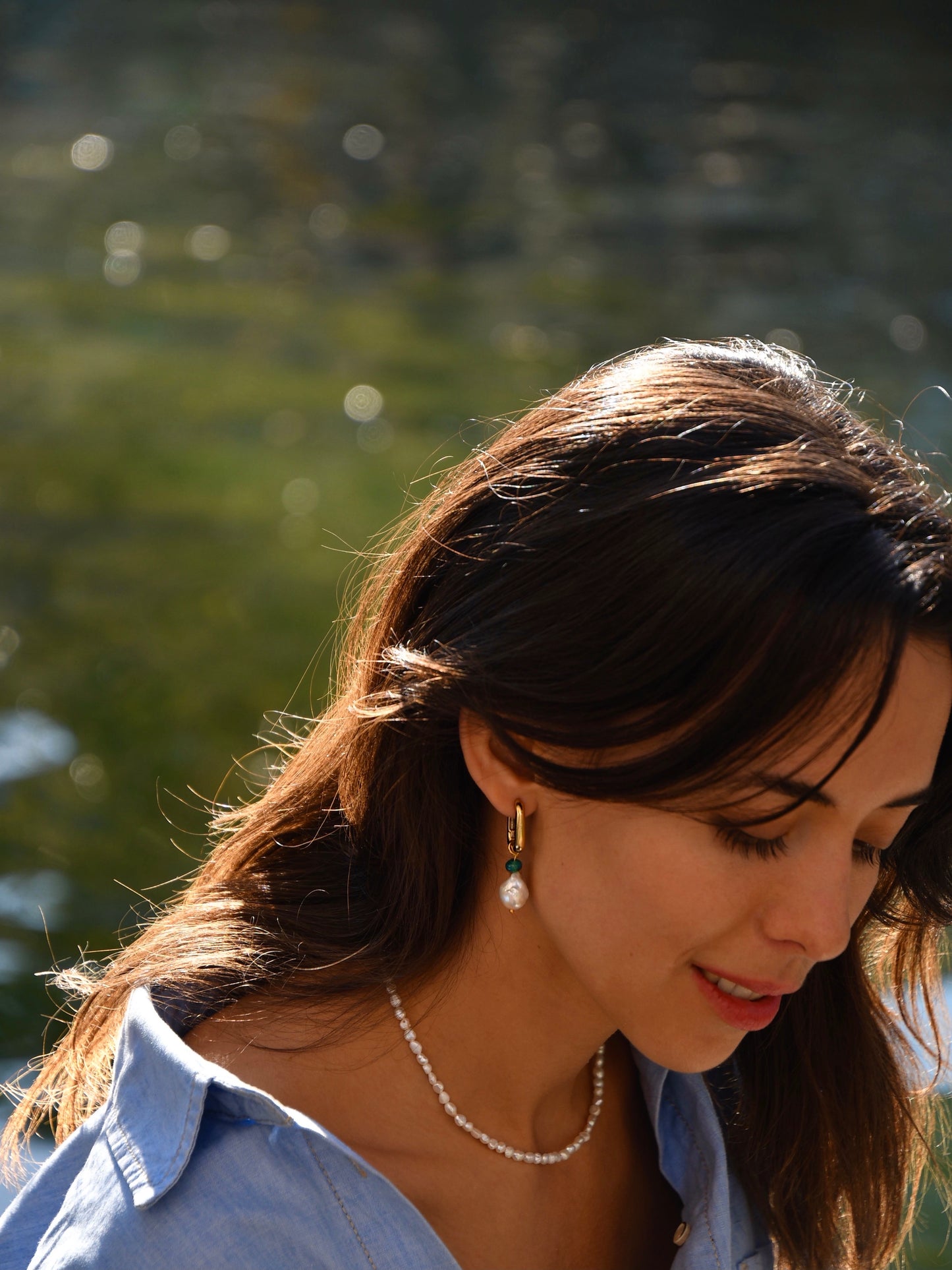 Model wearing freshwater baroque pearl earring with Green agate in a 24k gold-plated squared hoop and freshwater rice pearls necklace