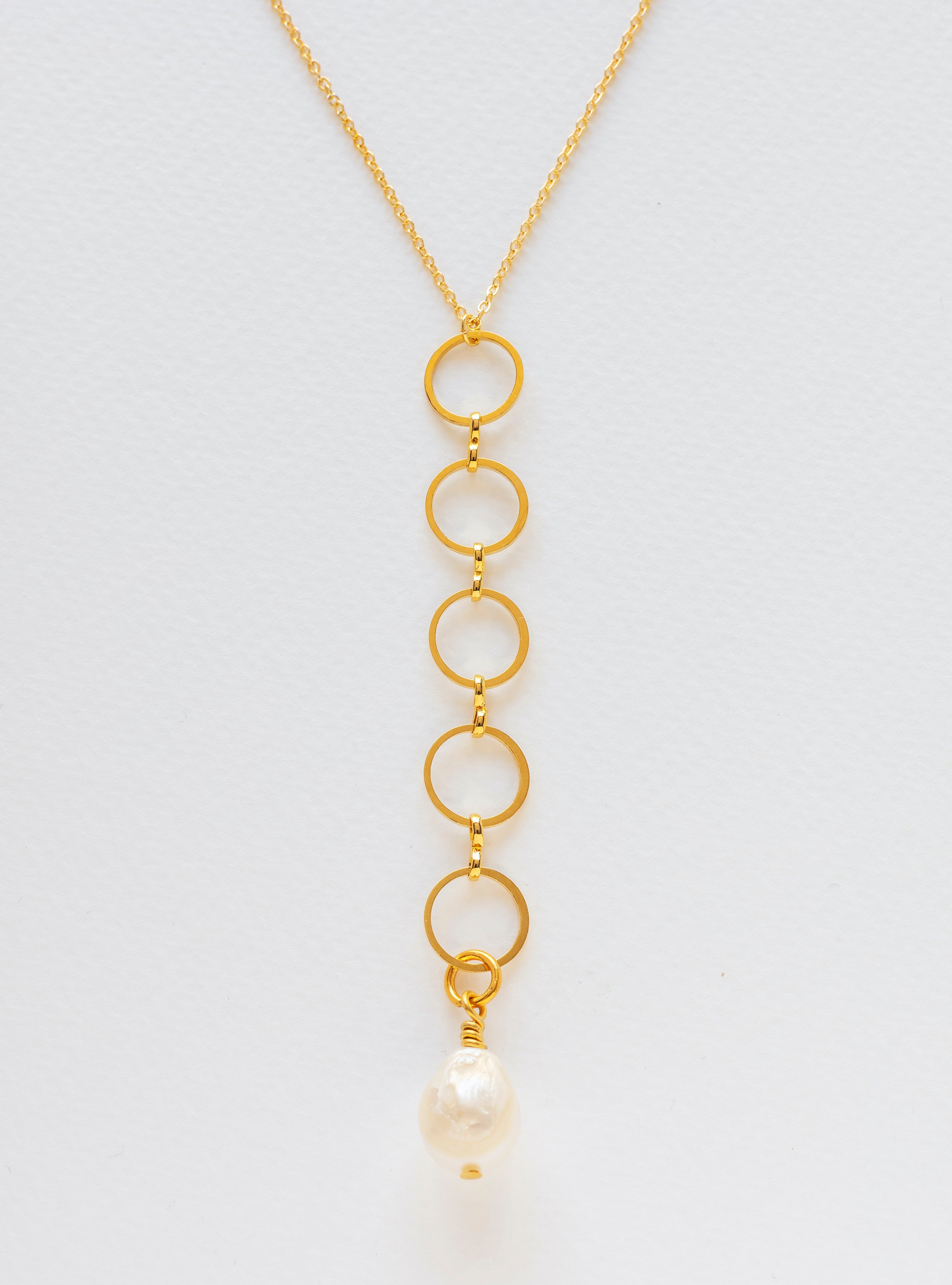 Long gold-plated necklace with circles interlinked and finished in a freshwater pearl.