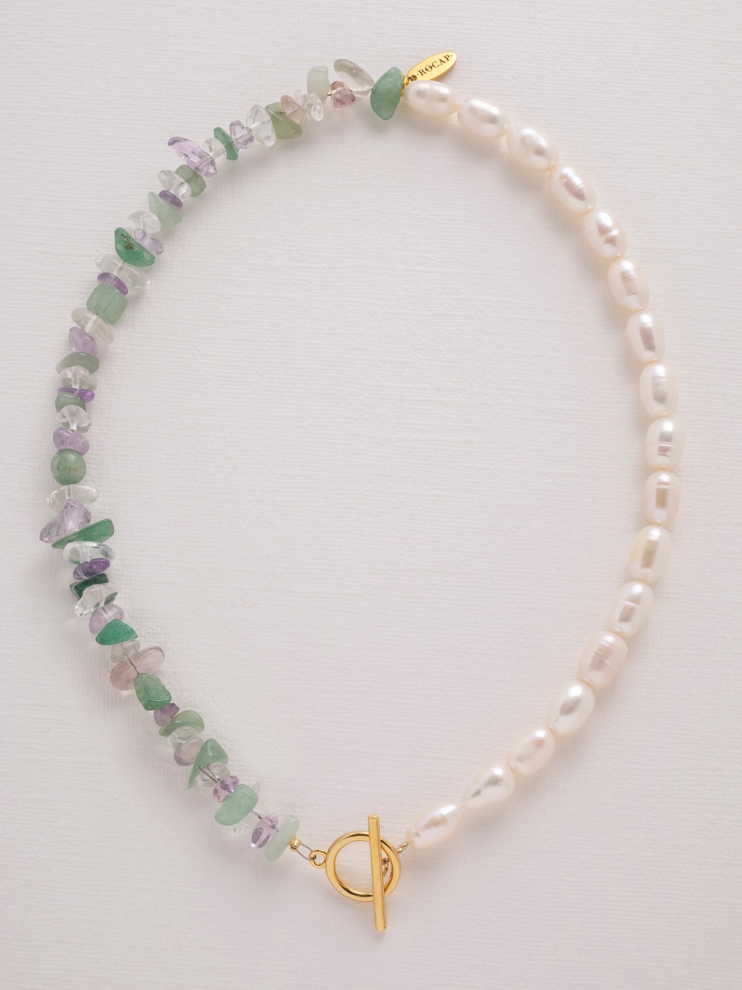 Asymmetric necklace with amethyst, green aventurine, crystal quartz and freshwater pearls with a gold-plated toggle clasp.